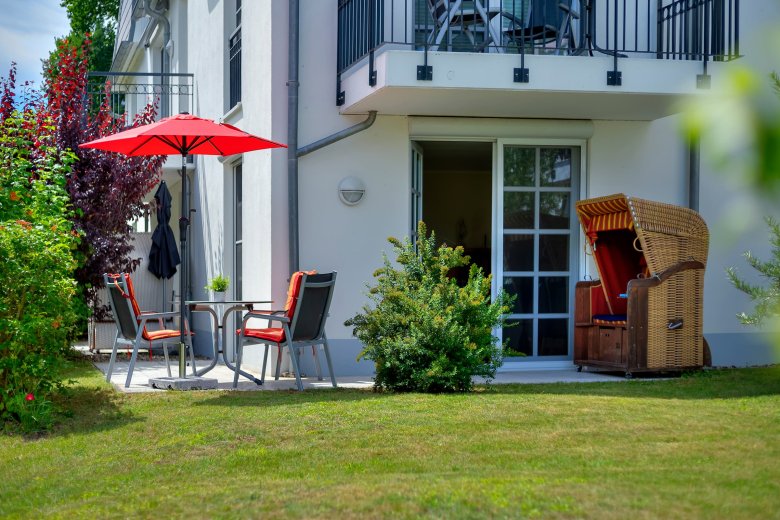 Blick vom Garten zur Terrasse mit Strandkorb an Wohnung 47 in Balm