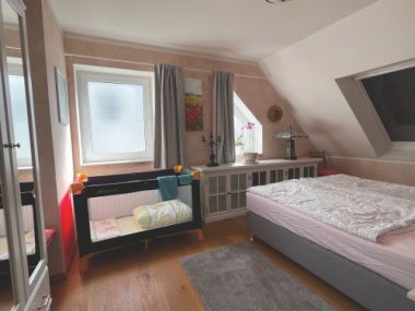Schlafzimmer mit Reisebett im Ferienhaus Fischersteig